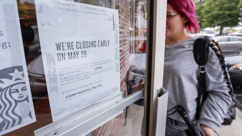 A sign alerts customers to the day's early store closing time at a Starbucks coffee shop in Atlanta, Georgia.