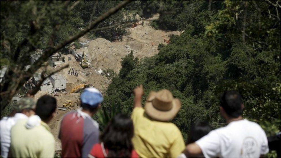 People watch an area affected by a mudslide in Santa Catarina Pinula on 7 October, 2015