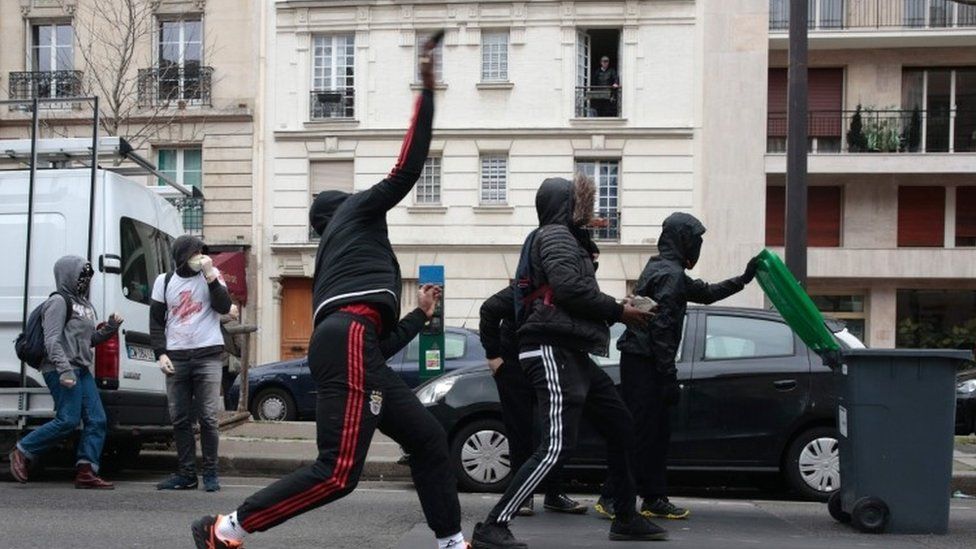 People throw projectiles at riot police during the demonstration against alleged police brutality in Paris (23 February 2017)