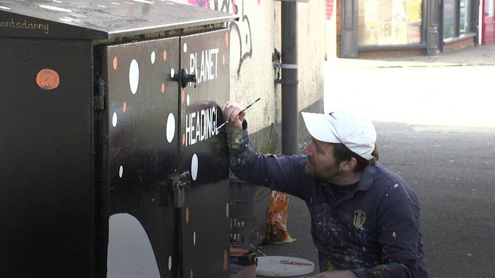 A man paints a cabinet