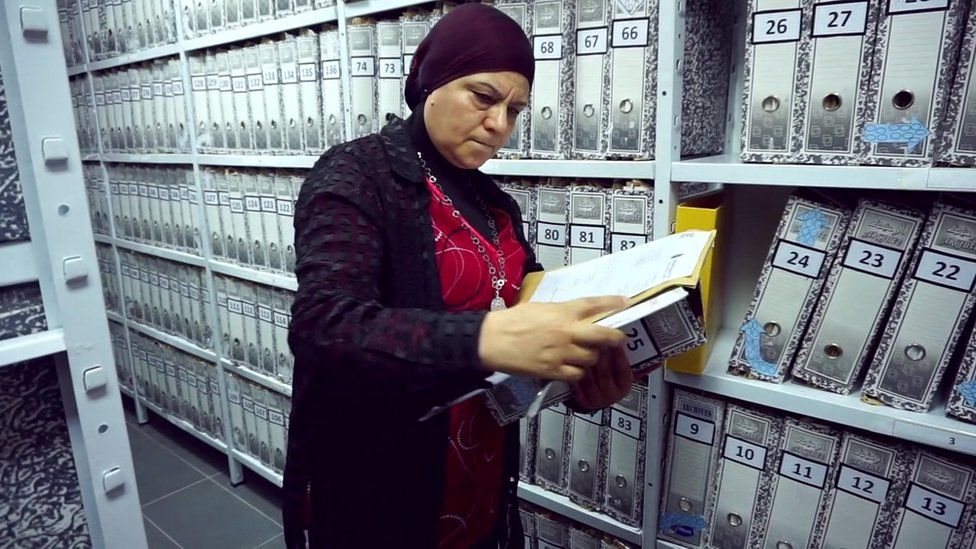 one of the researchers at the commission looks at files in its library