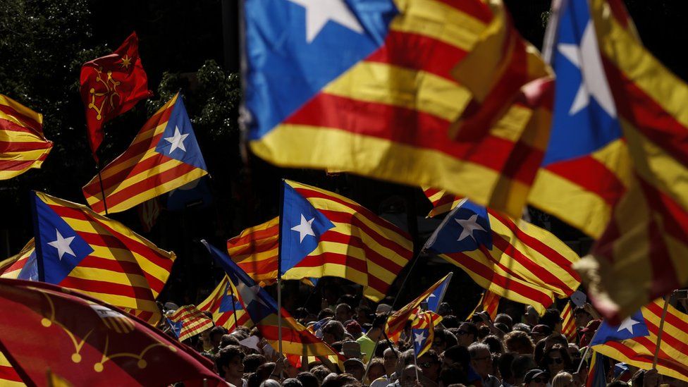 People wave 'Esteladas' (pro-independence Catalan flags) as they gather during a pro-independence demonstration, on September 11, 2017