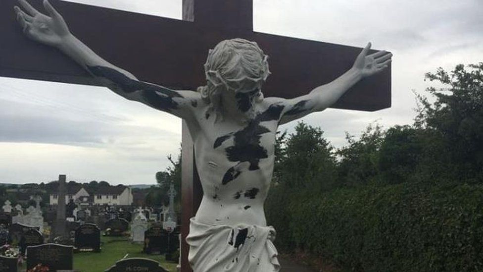 A damaged statue of Christ on a crucifix