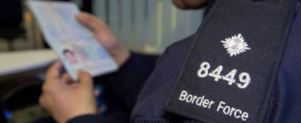 border force officer checking a passport