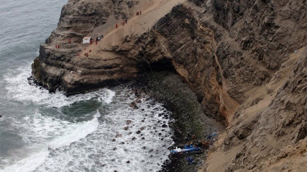 Rescue workers work at the scene after a bus crashed with a truck and careened off a cliff along a sharply curving highway north of Lima, Peru, January 3, 2018.