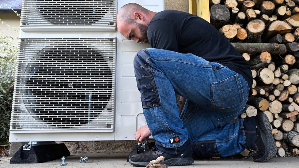 A worker installs a heat pump in a private home in western France on October 2, 2023