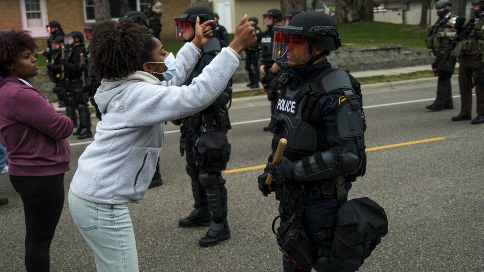 A woman confronts a police officer during protests in Minnesota