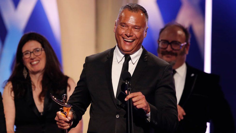 Stan Grant holding an ACTAA award and speaking