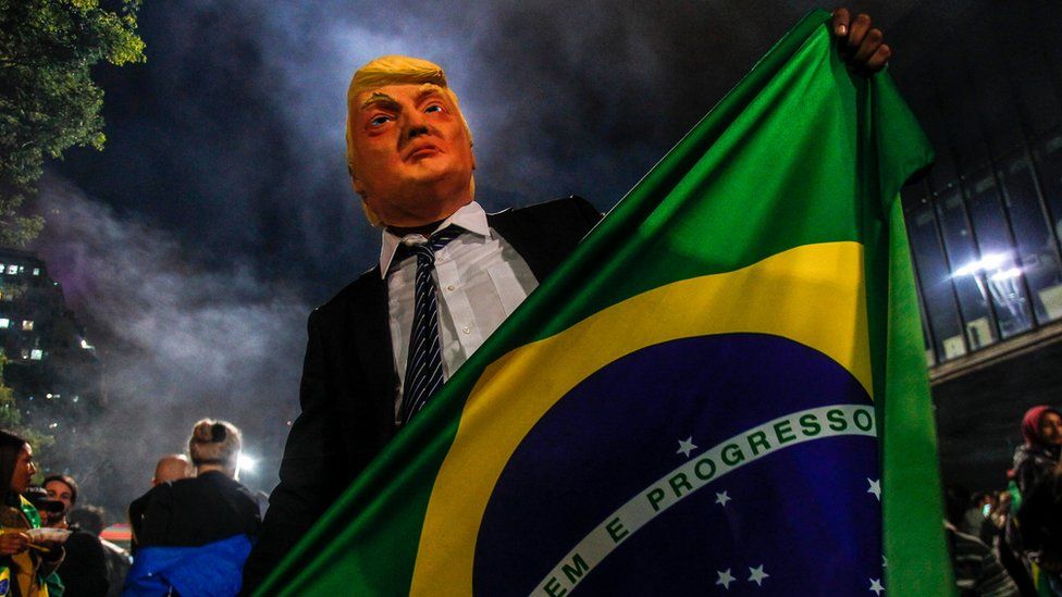 A supporter of Mr Bolsonaro wears a mask of US President Donald Trump