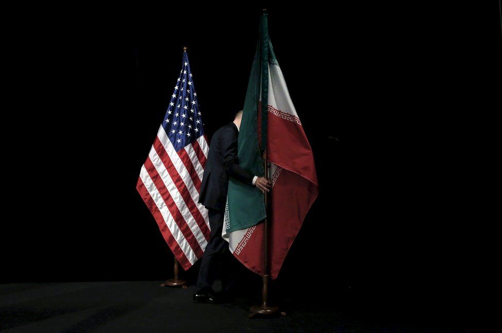 A staff member removes the Iranian flag from the stage during the Iran nuclear talks in Vienna, Austria, 14 July 2015