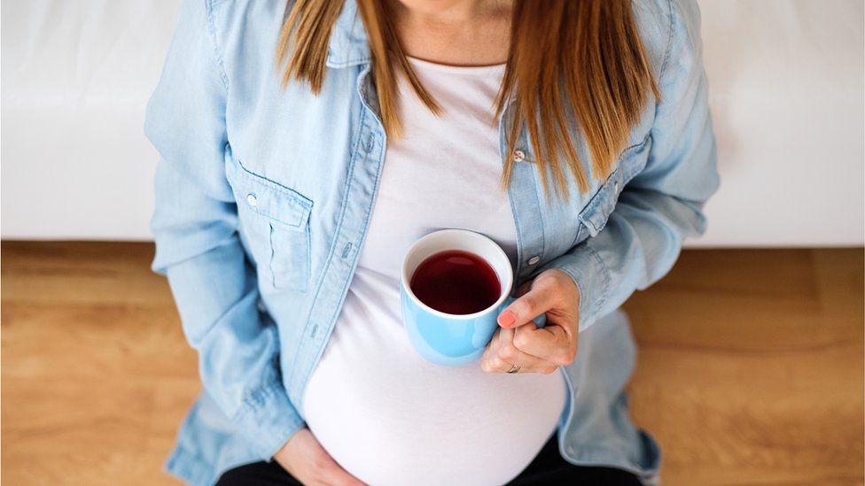 Pregnant woman with cup