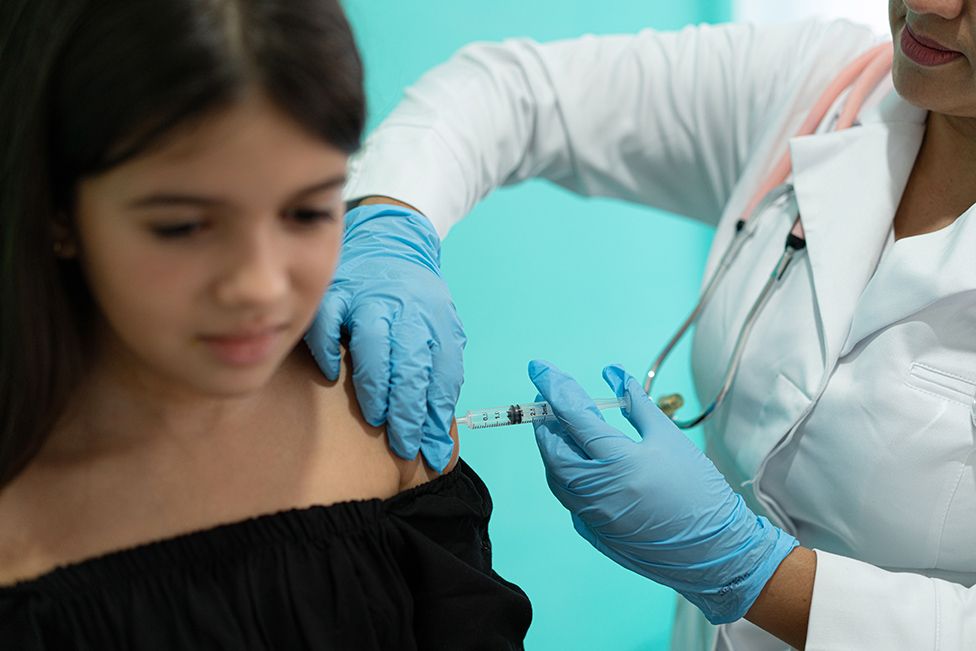 a teenage girl is injected with a vaccine (stock image)