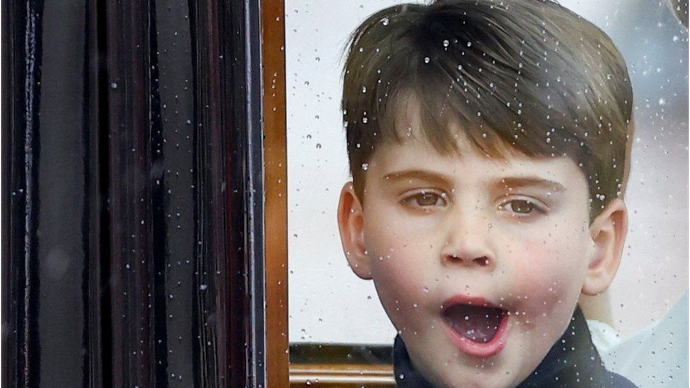 Prince Louis yawns as he travels in a coach