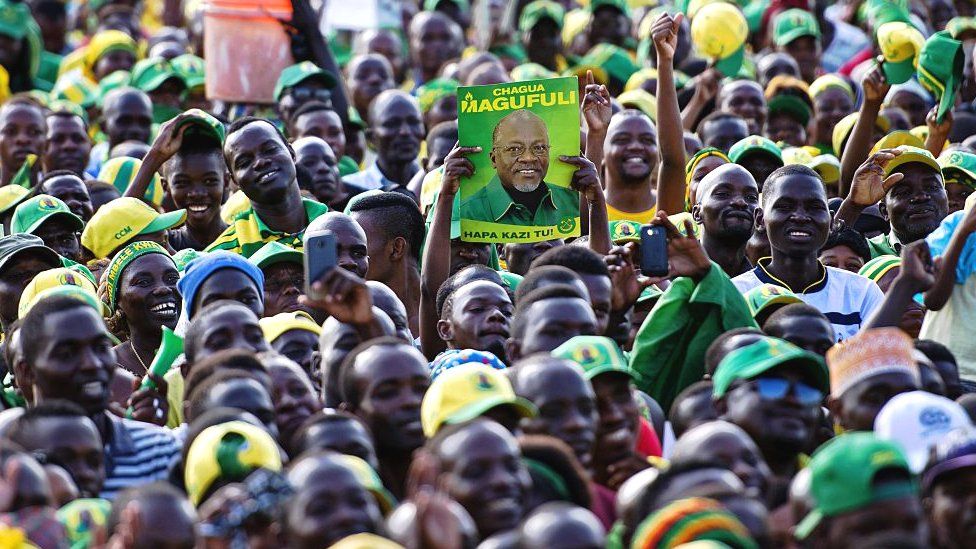 A man holds up a poster of CCM presidential candidate John Magufuli during a ruling rally in Dar es Salaam, Tanzania - 21 October 2015