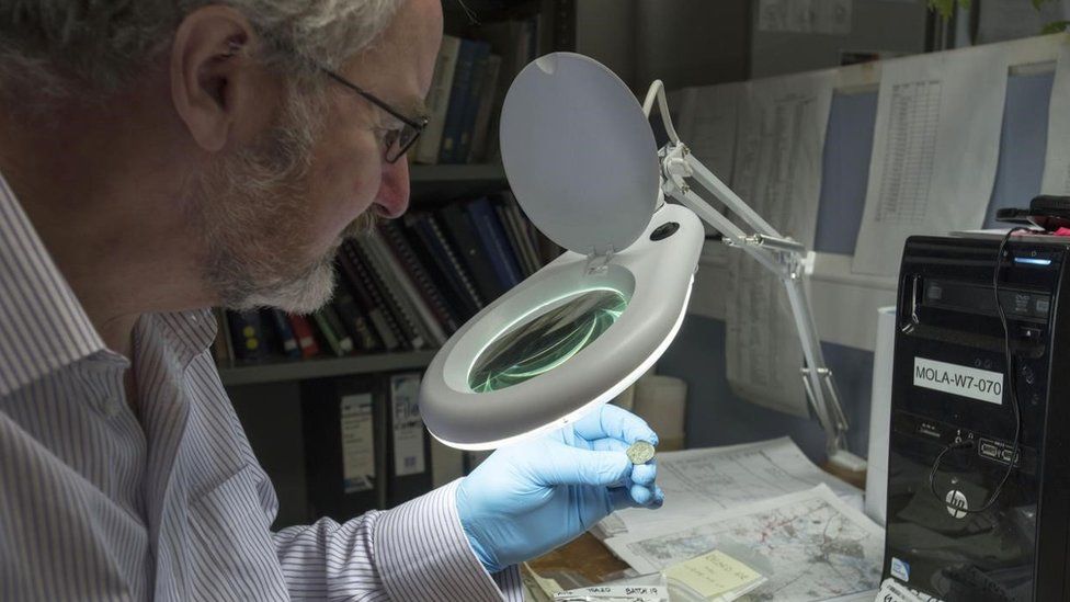 Dr Julian Bowsher examining coin