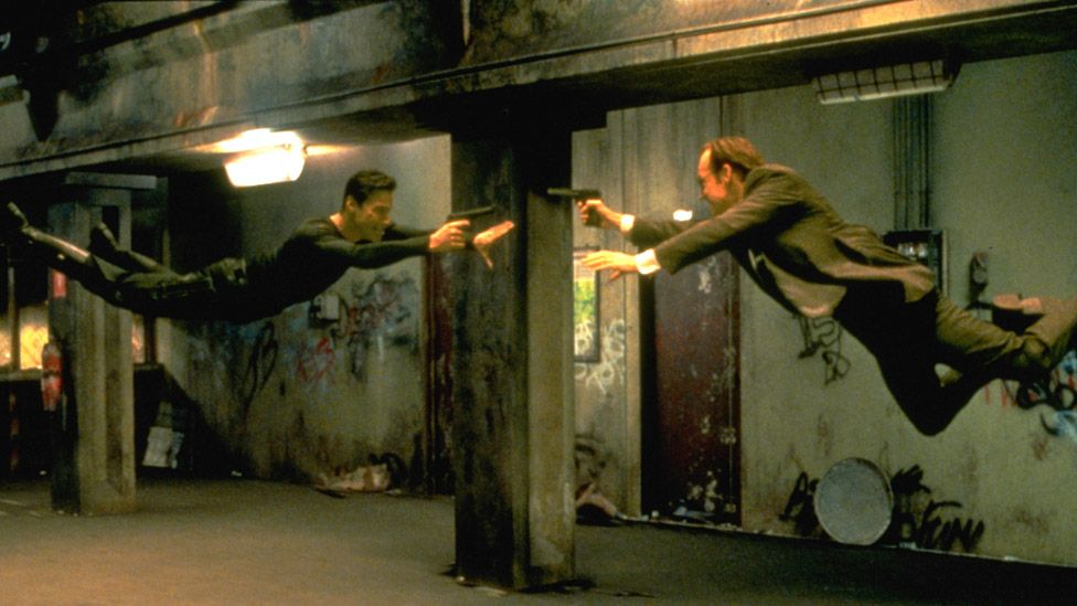 Keanu Reeves and Hugo Weaving face each other in a scene from 1999 movie The Matrix