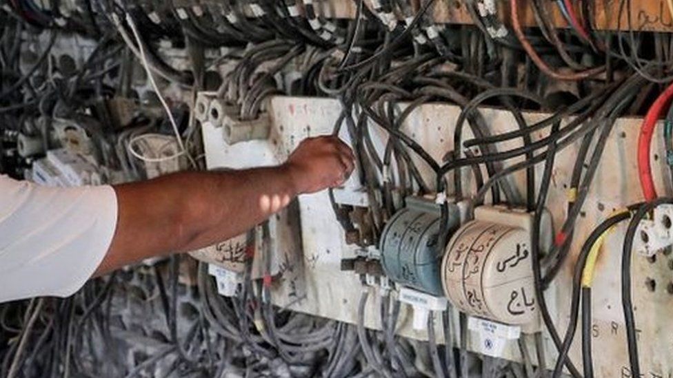 A technician controls an electric switchboard connecting homes to electricity generators in a suburb of Lebanon's capital Beirut, on June 23, 2021.