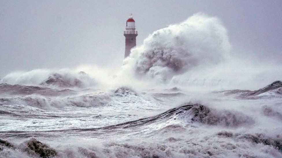 Enormous waves break over lighthouse