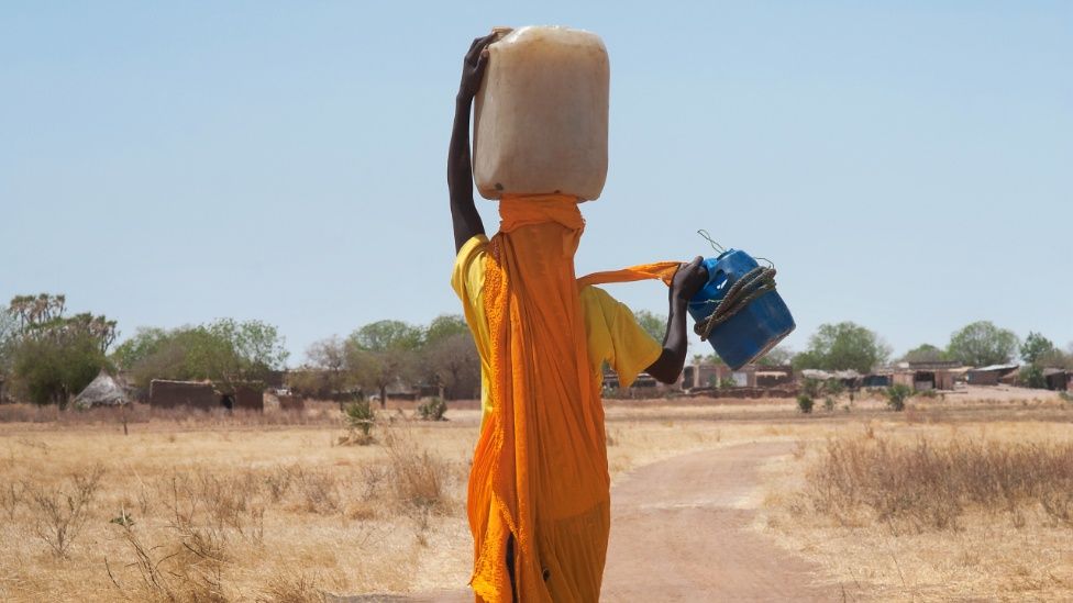 Суданская женщина, несущая воду