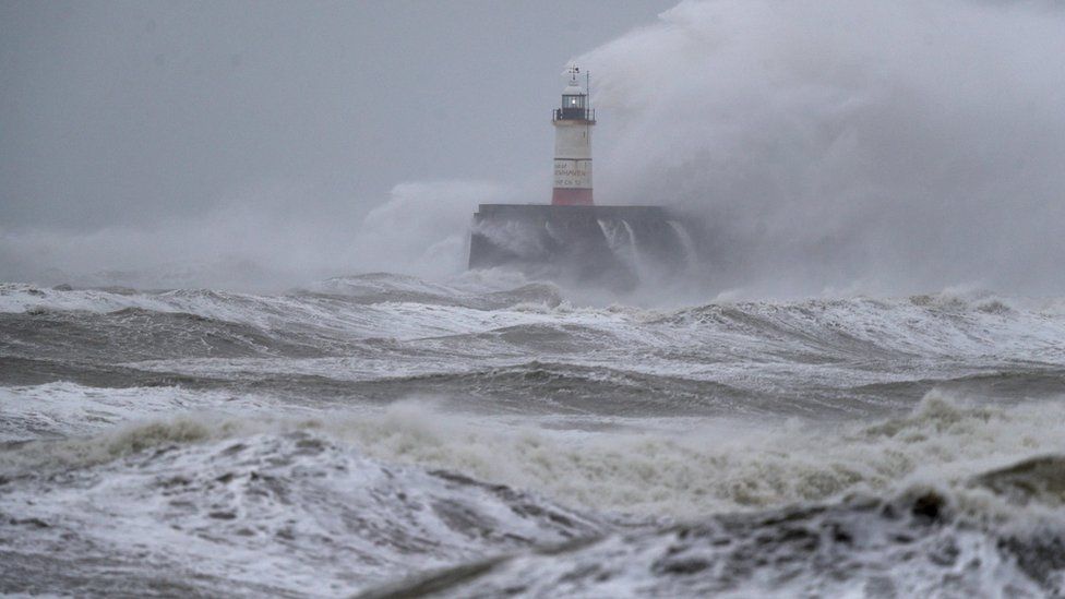 A lighthouse amid waves at Newhaven in East Susses during Storm Ciara