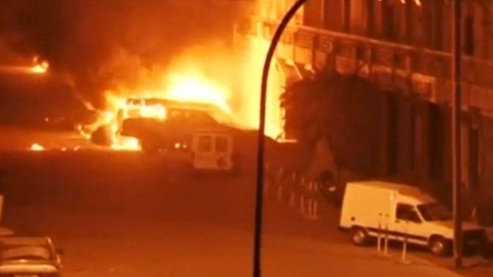 A view shows vehicles on fire outside Splendid Hotel in Ouagadougou