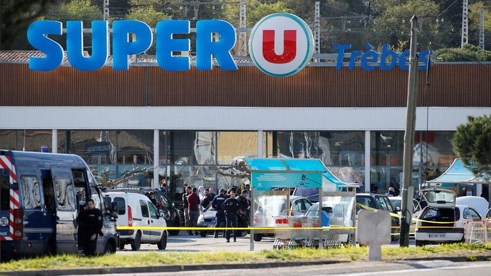 A general view shows gendarmes and police officers at a supermarket after a hostage situation in Trebes, France, on 23 March 2018