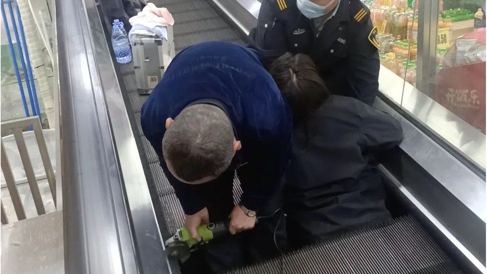 Woman trapped in travelator being rescued