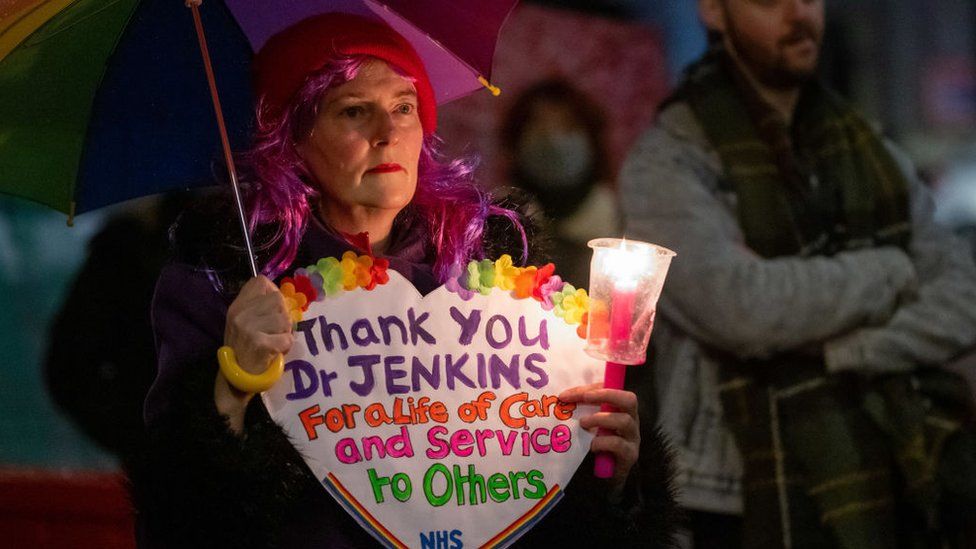 woman holding sign at vigil