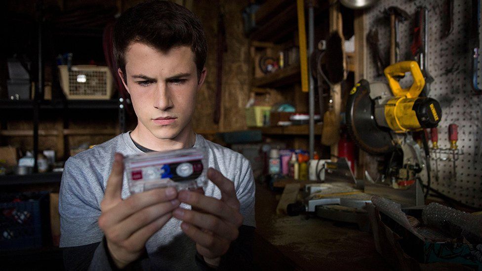 13 Reasons Why character Clay Jensen holds a cassette tape