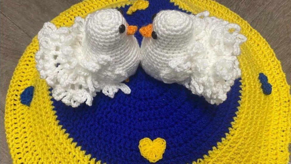 Crochet tribute to Ukraine showing two doves on a blue and yellow background