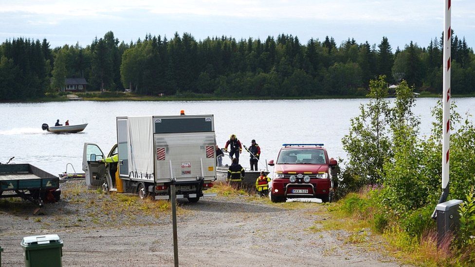 Emergency services with plane wreckage parts arrive at a small harbour near the accident site at Ume river outside Umea, Sweden, on 14 July 2019