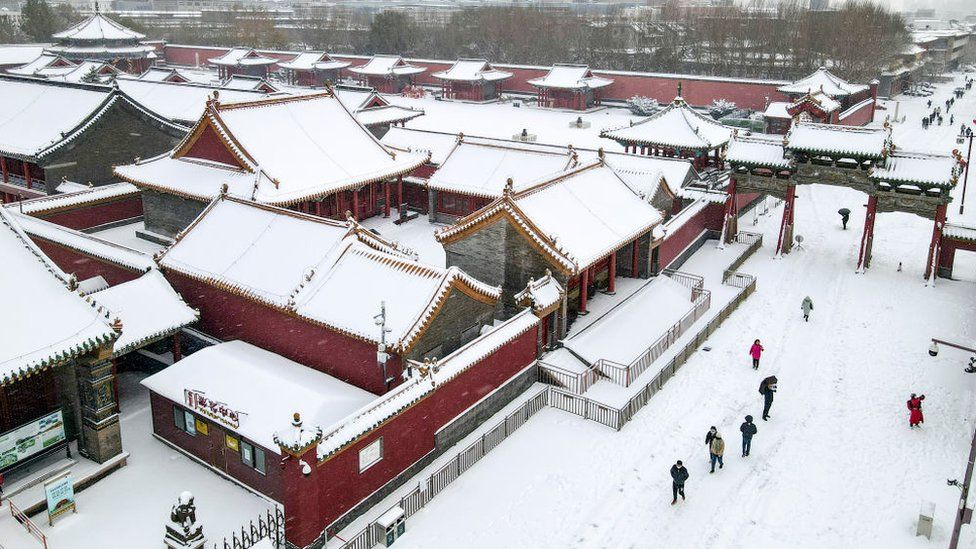 Tourists visit the Shenyang Imperial Palace during a heavy snowfall on November 8, 2021 in Shenyang, Liaoning Province of China.