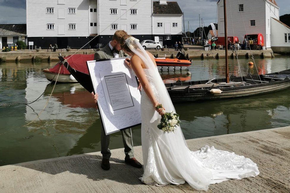 A newly-married couple signing the declaration at Whisstocks Quay in Woodbridge