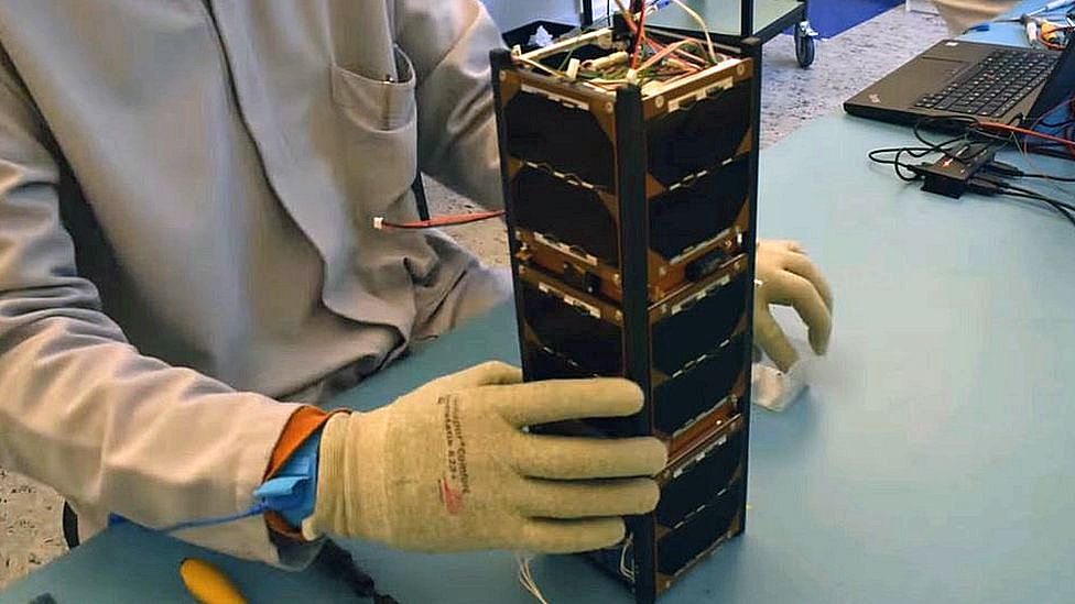Still from video of a nano-satellite being assembled by hand