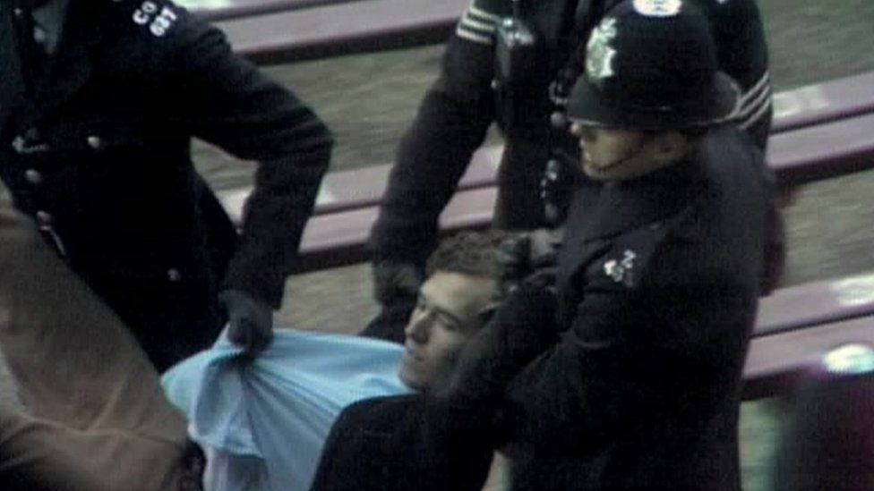 Peter Hain being dragged away by police after invading a sports pitch