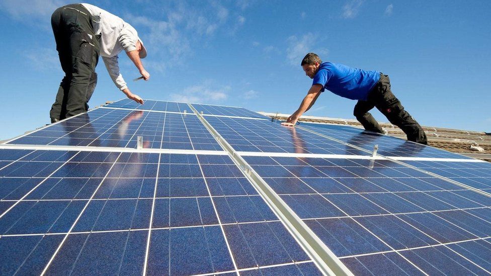 Dois homens instalando painéis de energia solar