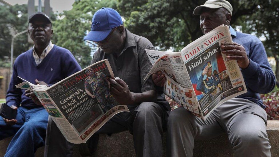 Kenyan men read local newspapers with the headline announcing the death of Kenya's Chief of Defence Forces (CDF), General Francis Omondi Ogolla and nine other senior military officers who died in a helicopter crash, in the streets of Nairobi, Kenya, 19 April 2024