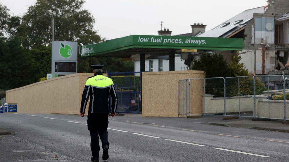 An Irish police officer walks towards the scene of the explosion at the Applegreen service station in Creeslough