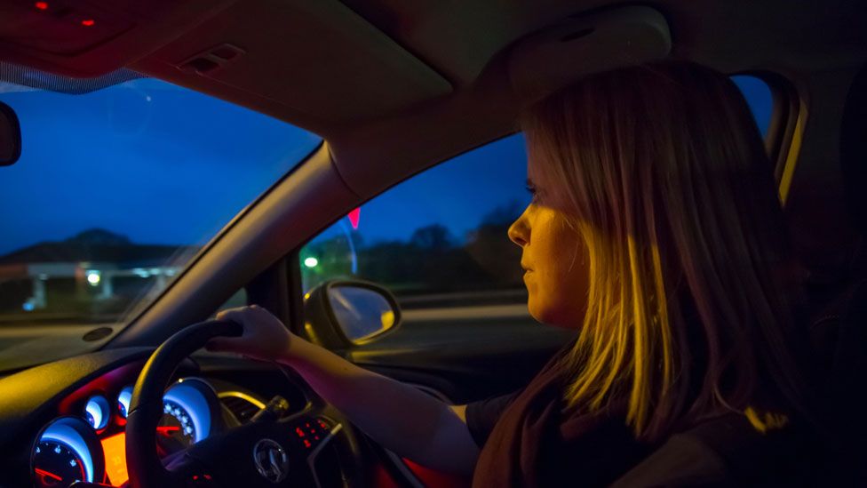 Woman driving at night
