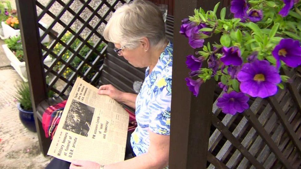 Audrey Robinson reads a newspaper article about her brother