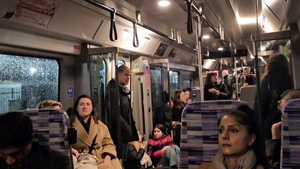 Passengers wait inside a train stuck on the Elizabeth line