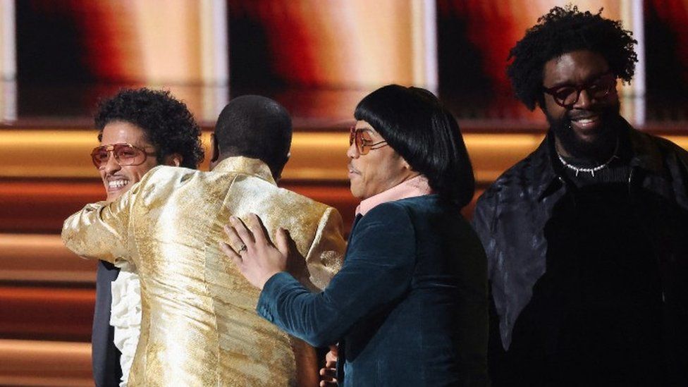 Bruno Mars, Dernst Emile II and Anderson .Paak of Silk Sonic accept the song of the year award (nicely) from Questlove
