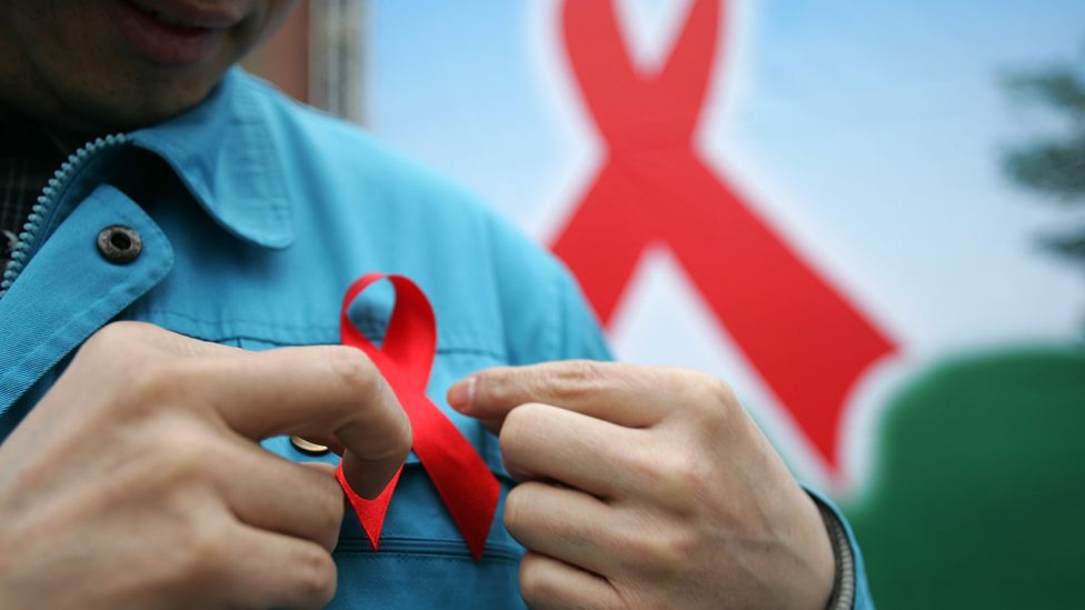 Man adjusting Aids awareness ribbon