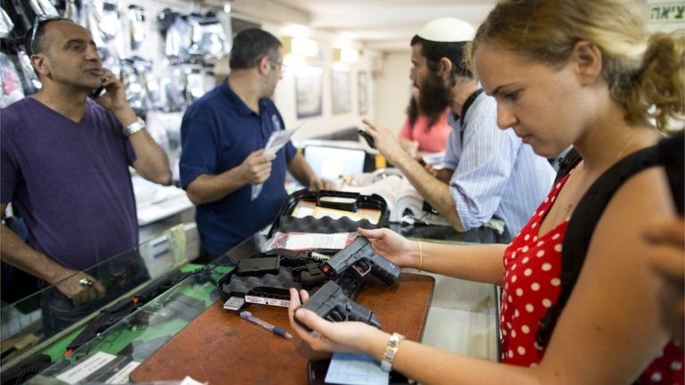 Woman examines gun in a weapons shop in Jerusalem (19/10/15)