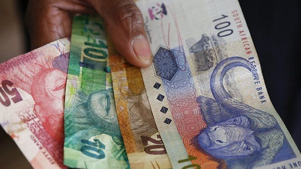 A South African woman holds the South African Rand bank notes in Cape Town