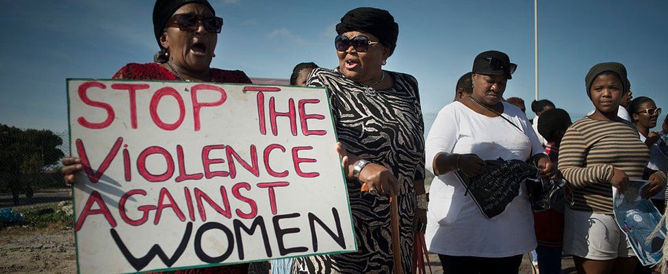 Women hold signs during a protest against ongoing violence against women, in Gugulethu, on May 21, 2016, about 20 Km from the centre of Cape Town.