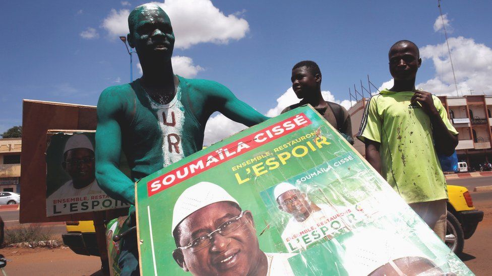 A supporter of presidential candidate Soumaila Cisse holding a campaign poster