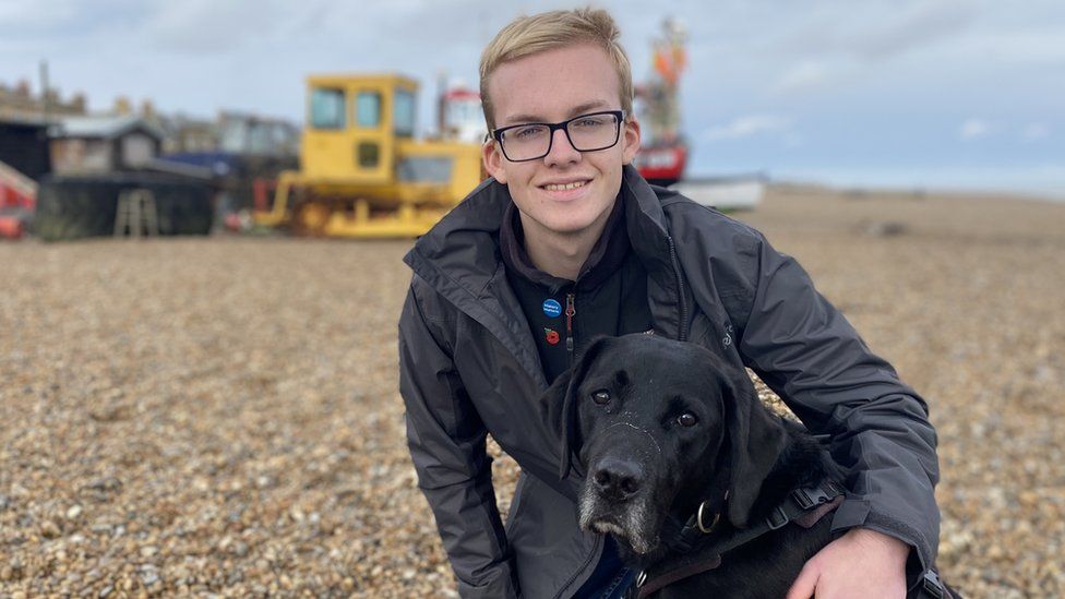 Daniel on a beach with his dog