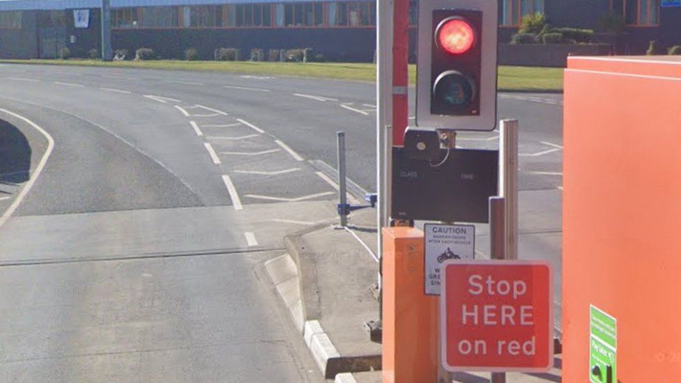 Red traffic light and sign saying Stop Here on Red at a Tyne Tunnel barrier-free lane