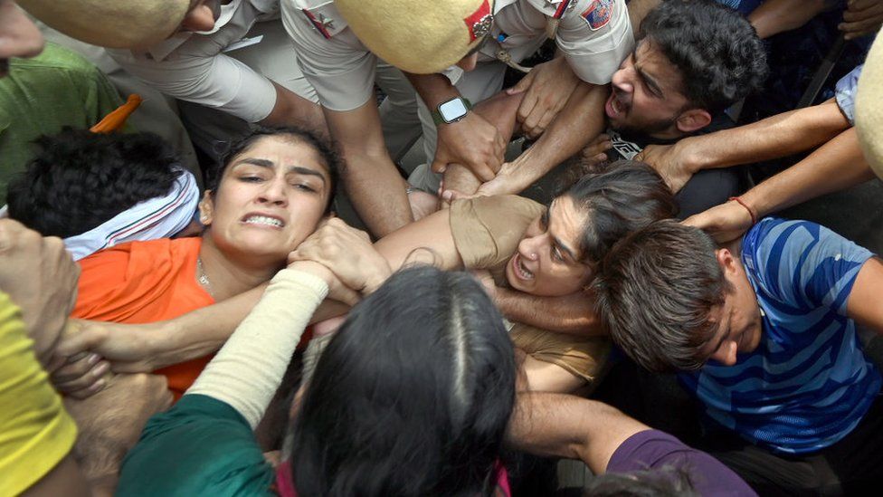 Security personnel detain wrestlers Vinesh Phogat and Sangeeta Phogat during wrestlers' protest march towards new Parliament building, on May 28, 2023 in New Delhi, India.